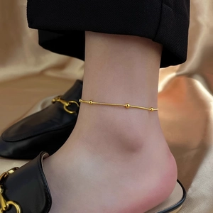 Detailansicht eines goldenen Schlangenfußkettchens mit Perlen zu Loafers