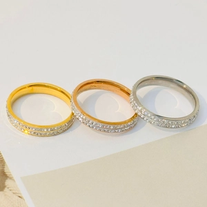 Detail of three minimalist rings in gold, rose gold and silver with double row zirconia