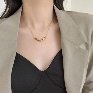 Minimalist gold titanium steel necklace featuring seven geometric cube beads on a thin chain