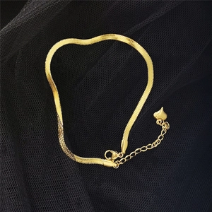 Détail de la chevillère chaîne serpent dorée avec fermoir mousqueton et cœur