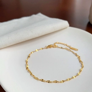 Detalle de la tobillera de acero inoxidable bañada en oro 18k con cadena ajustable fina