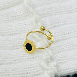 Primer plano de anillo de acero de titanio dorado con números romanos e incrustación negra