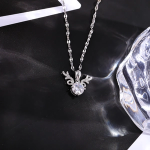 Detailed view of silver elk pendant necklace with a sparkling round zircon on black background