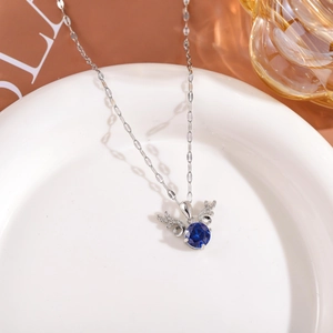 Detail of silver elk necklace featuring a round blue stone and diamond-set antlers