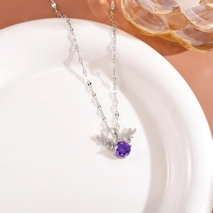 Detailed close-up of a silver angel wing necklace featuring a brilliant purple gemstone