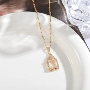 Macro view of golden square pendant with champagne gemstone and micro-pave crystals