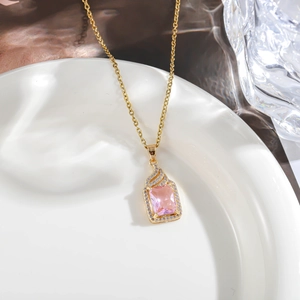 Detailed close-up of a square pink zircon pendant with crystals on a golden chain