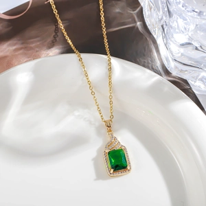 Macro shot of emerald-cut green stone pendant surrounded by sparkling white zircons