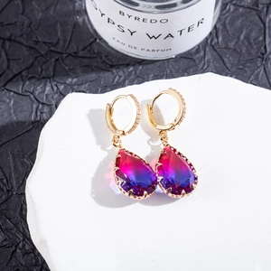 Detailed macro view of teardrop gradient purple gemstone earrings on white stone