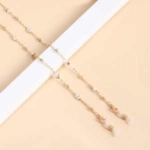 Chaîne de lunettes dorée avec perles et croissants de lune sur fond neutre