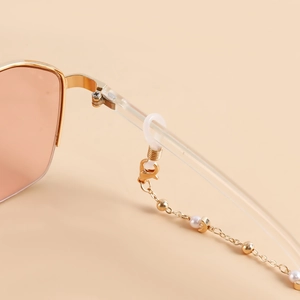 Chaîne à lunettes dorée avec perles et croissants sur des lunettes rétro