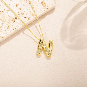 Dettaglio della collana con ciondolo a lettera N placcata oro con pietre di zirconia lucida