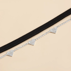 Detail van elastische beenketting met sprankelende zilveren hartvormige strass-stenen