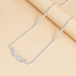 Detailed close-up of a silver double-row rhinestone body chain with angel wings pendant