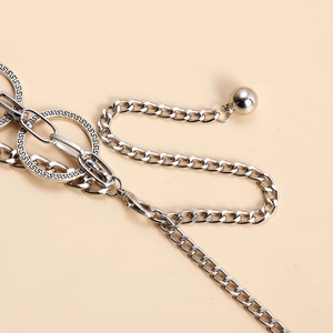 Detailed macro view of silver layered body chain featuring Greek key engraved metal rings