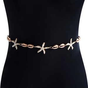 Detailaufnahme der goldenen Metall-Taillenkette mit Muschel- und Perlen-Seestern-Anhängern