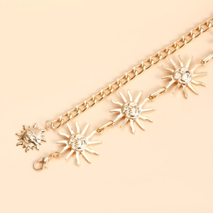Close-up of golden sun-face pendants on metal chain belt with lobster clasp fastener