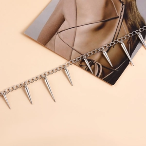 Close-up of silver punk body chain featuring geometric rivet spikes and polished O-chain link
