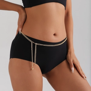 Cintura a catena dorata minimalista con ciondoli a sfera mostrata su abbigliamento nero