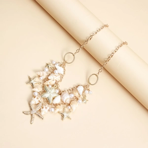 Détail de la chaîne de taille bohème dorée avec coquillages, étoiles de mer et perles