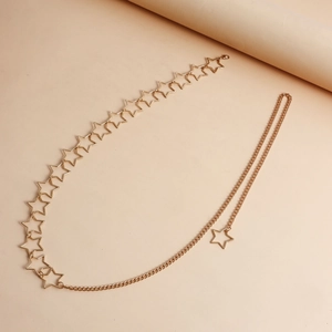 Detail of gold metal star waist chain featuring hollow pentagram links and a drop star charm