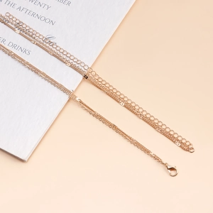 Detail shot of golden multi-layer body chain with lobster clasp and extension links