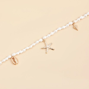 Detalle de cadena de cintura playera con colgantes dorados de estrella de mar y concha
