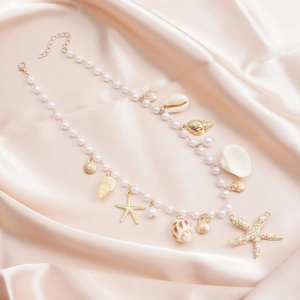 Détail de chaîne de corps avec perles d'imitation, coquillages et pendentifs étoile
