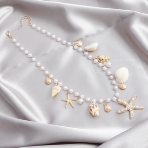 Détails de breloques étoile de mer et coquillages sur une chaîne de corps en perles