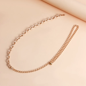 Detail of minimalist gold metal waist chain with elegant double-layered link and round bead