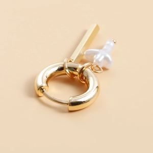 Macro view of gold hoop earring featuring a polished rectangular bar and baroque pearl