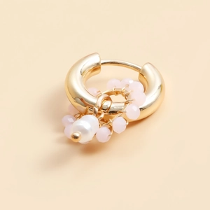 Detail of gold geometric hoop earrings with pink crystal beads and a white pearl accent
