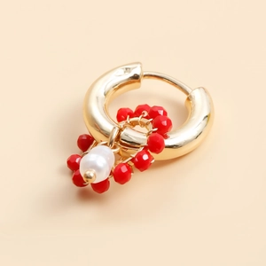 Detail of gold hoop earring with red faceted beads and white baroque pearl pendant