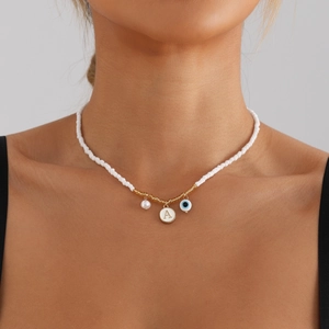 White beaded necklace with gold A-letter charm, pearl and blue evil eye pendant