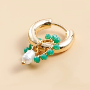 Close-up of golden woven hoop earring with green faceted beads and white pearl pendant