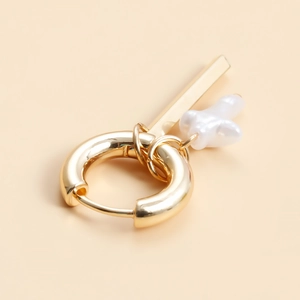 Detail of gold geometric hoop earrings featuring detachable bar and baroque pearl charms