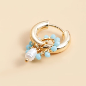 Detail of gold woven hoop earrings with light blue beads and white baroque pearls