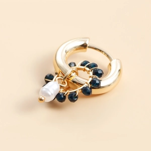 Detail of gold geometric hoop earrings with blue crystals and baroque pearl pendant