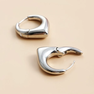 Boucles d'oreilles créoles C argentées polies au design punk géométrique moderne