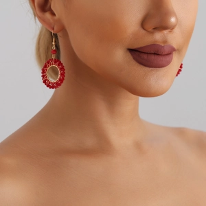 Handcrafted circular woven drop earrings with red crystal beads and golden wire