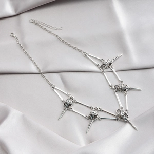Detailed close-up of gothic bird skull pendants and bone links on a silver necklace chain