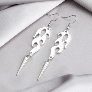 Macro shot of silver flame shaped earrings with punk style metal spike pendants