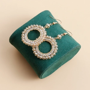 Close-up of handmade gold hoop earrings with champagne crystal beads on green velvet
