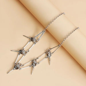 Detailed close-up of vintage gothic bird skull necklace pendants with silver finish