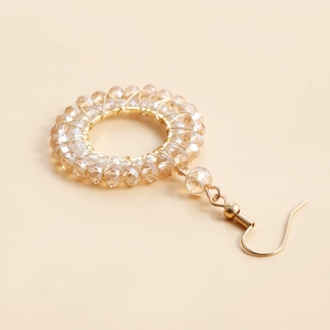 Detailed close-up of champagne crystal beaded hoop earring with gold wire wrapping
