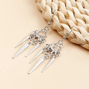Macro detail of gothic tassel spike drop earrings in silver finish with metal chain links