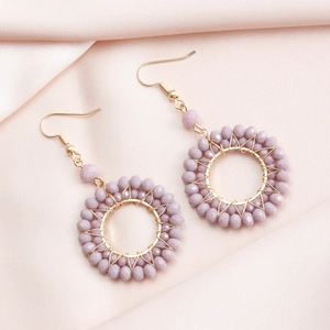 Detailed view of hand-wrapped gold hoop earrings with lilac faceted crystal beads