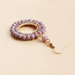 Detailed view of handmade lavender crystal beaded hoop earrings with gold woven wire accents