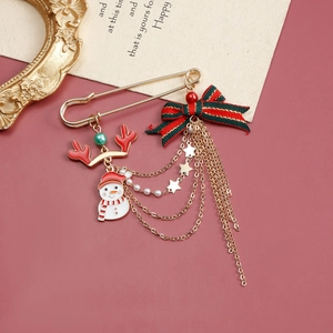 Broche de Noël avec bonhomme de neige, bois, nœud et longs glands sur fond rouge