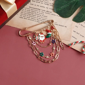 Christmas Santa Claus brooch with gold chains and enamel charms on a festive background